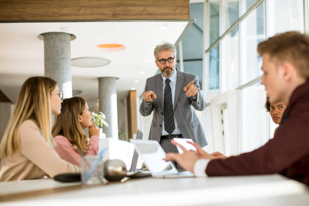 istock Mature businessman explaining strategy to group of multiethnic business people while working on new project 1257468034