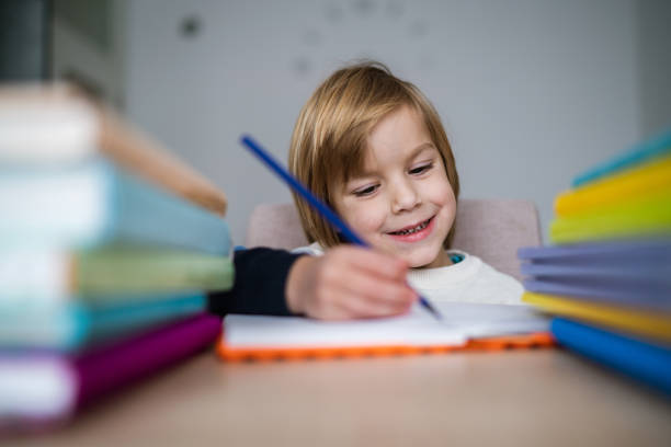 istock Smiling boy writing homework at home 1257469131