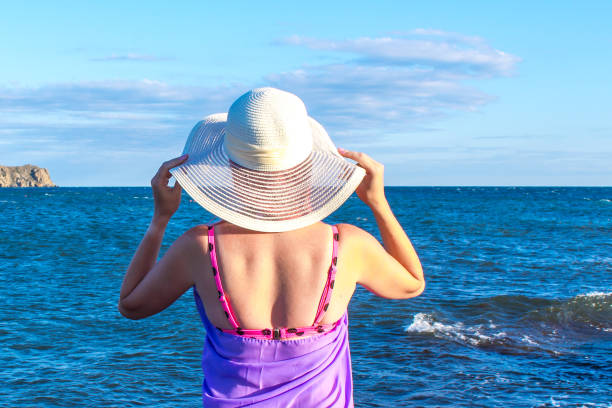 istock Girl in a hat on the beach 1257469475