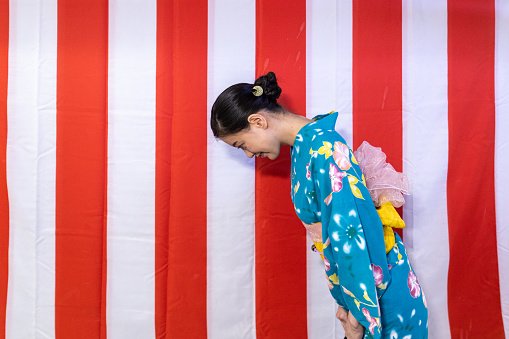 Young woman bowing in front of the red-white lines
