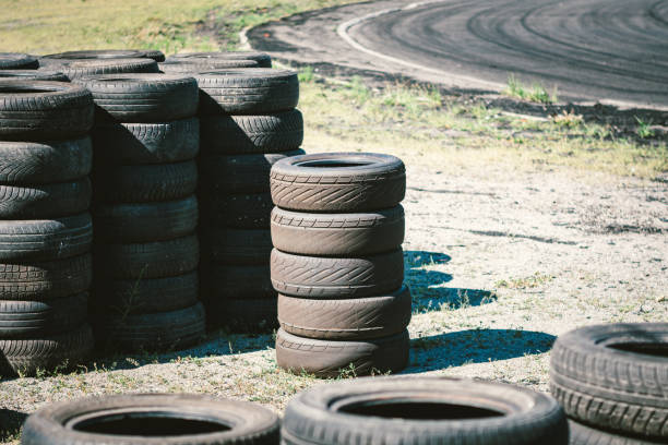 Many old used car tires stacked on top of each other on Automobile sports complex. Industrial landfill for the processing of waste tires and rubber tyres. Old rubber wheels. Tires on the autodrome. muchos neumáticos viejos de automóviles usados apilados uno encima del otro en el complejo deportivo automobile. vertedero industrial para el procesamiento de neumáticos de desecho y neumáticos de caucho. viejas ruedas de goma. neumáticos en el autód