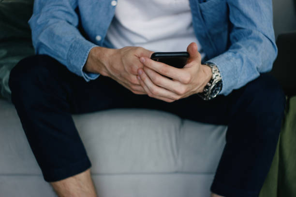 istock A young man at home with a mobile phone in his hands. 1257472174