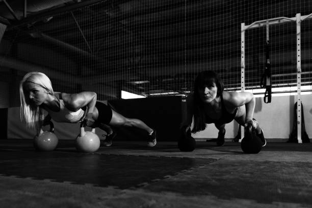 istock Fitness Couple Exercising With Kettle-bell 1257481900