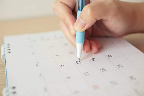 istock Hand with pen writing on calendar date 1257482125