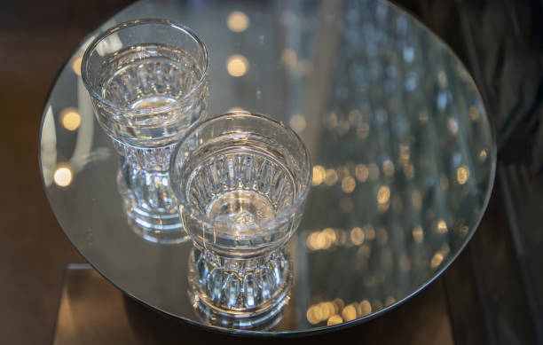 istock Two Glasses of pure water on a glass surface round table. 1257483069