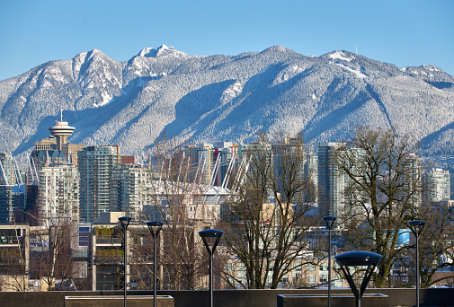 Office Towers of Vancouver against the peaks of the Coast Mountains on a sunny, postcard morning.