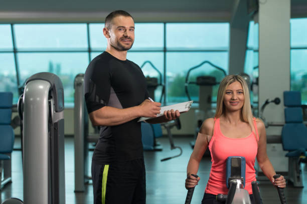istock Gym Coach Helping Woman On Back Exercise 1257483250