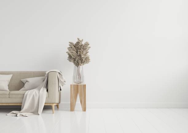 istock Empty living room with brown color sofa/ornamental glass jar and table on empty white wall background. 1257484798