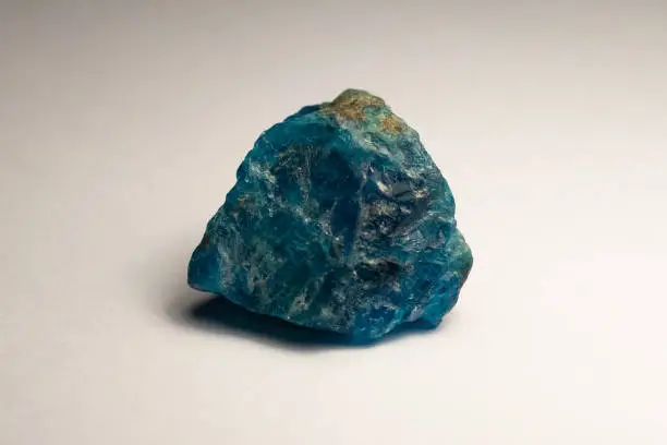 Rough apatite gemstone on a white background.