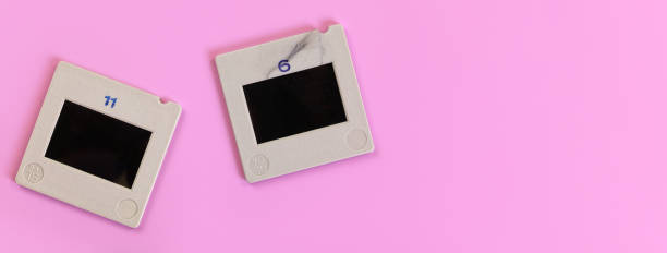 istock Two diapositive photo slides on pink table, view from above, space for text right side 1257487430