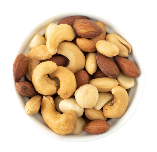 istock Nuts in top view circle shaped ceramic bowls isolated on white background. Various nuts (almonds, macadamia, cashew, peanuts). Mix nut healthy ingredients food. 1257487714