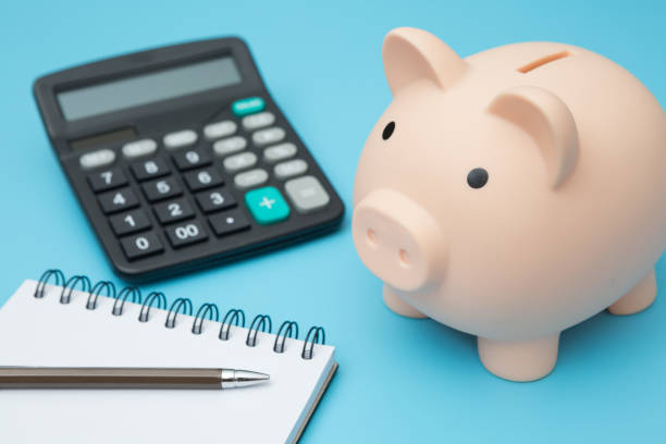 istock Notebooks, Piggy bank, calculator, pens on blue background and copy space 1257496997