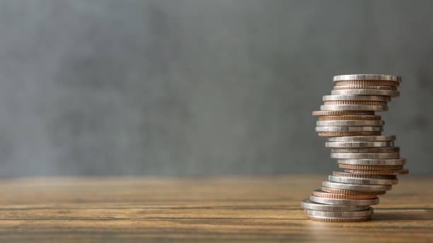 istock Stack of coins on wood desks and loft wall backgrounds with sunlight 1257497000