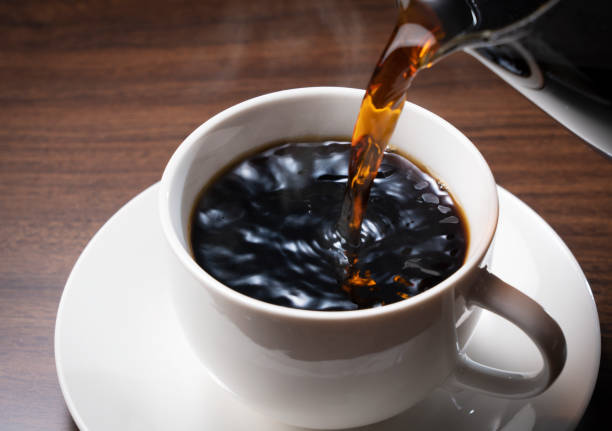 istock Pouring hot coffee against a dark wooden backdrop 1257499490