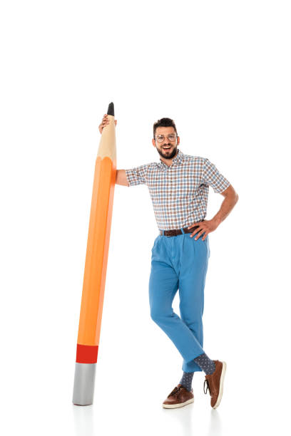 istock Smiling nerd with hand on hip standing near big pencil on white background 1257500555