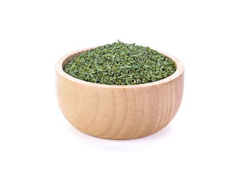 Dried parsley in wooden bowl on white background
