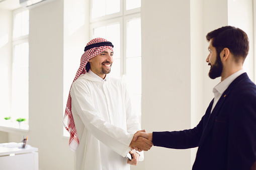 Handshake of arabic and european businesspeople. Businesspeople hands makes a handshake in the office. The conclusion of the contract by business people.