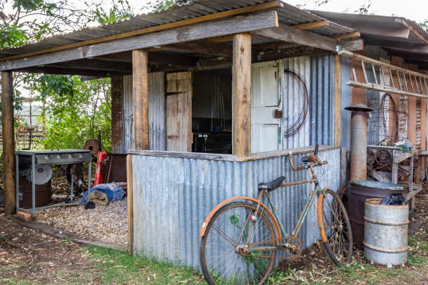 An old farm shed with old bike and BBQ