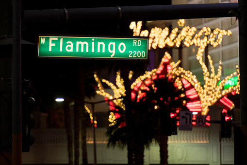 Las Vegas, USA - Sep 22, 2019: A Flamingo street sign early in the evening with the Flamingo Hotel in the background.
