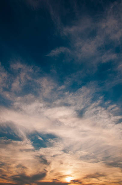 istock Golden sunset extends to deep blue night sky, cirrus clouds 1257527857