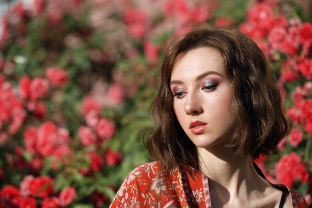 istock Young beautiful dreamy woman with red roses. 1257530822