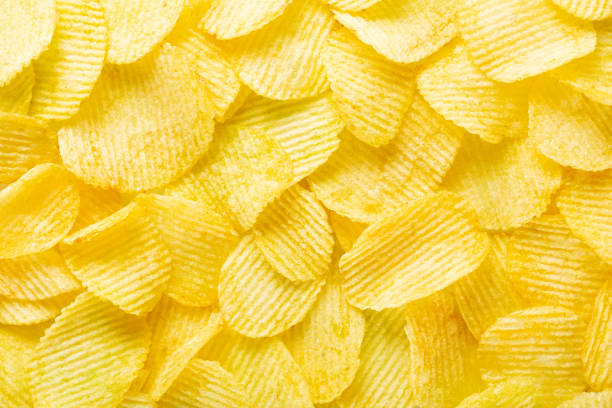 hintergrund gewellte goldene chips mit textur - potato chip stock-fotos und bilder