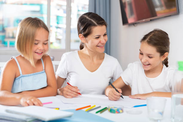 istock Happy mother teaches her daughters to draw 1257531197