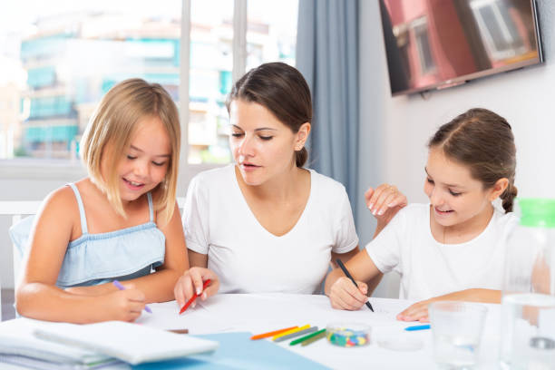istock Young woman and two daughters drawing together 1257531202