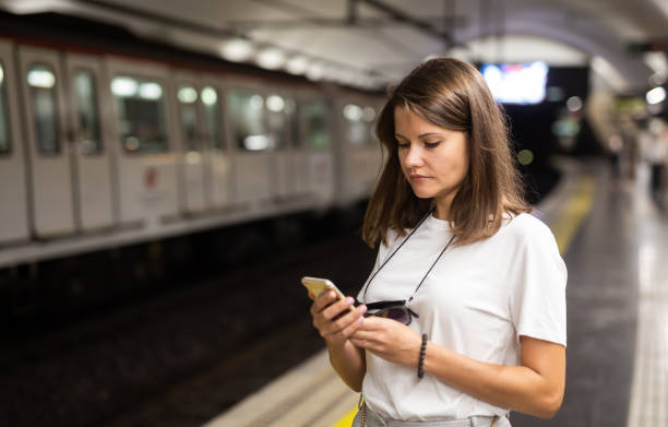 istock Woman waiting subway car using phone 1257537610