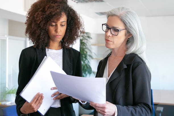 istock Confident focused female boss in glasses reading report 1257537754