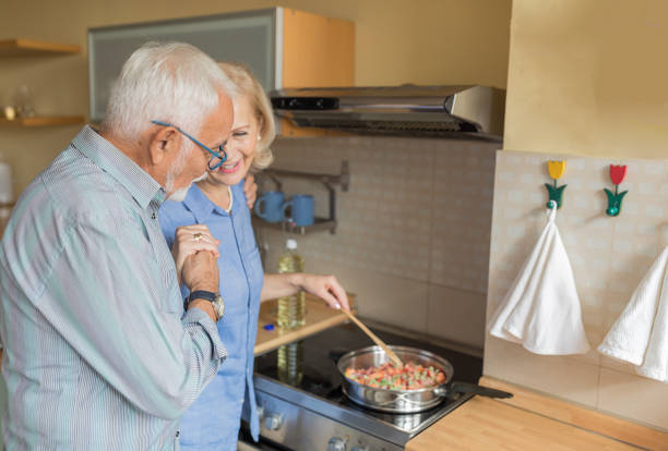 istock Happy Older Woman and her Husband are Spending a Nice Time While Enjoying in Dinner Preparation at Home. 1257538709
