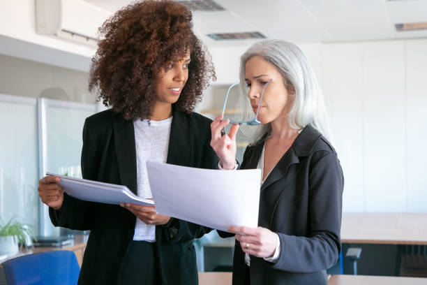 istock Confident female partners discussing document in office room 1257538813