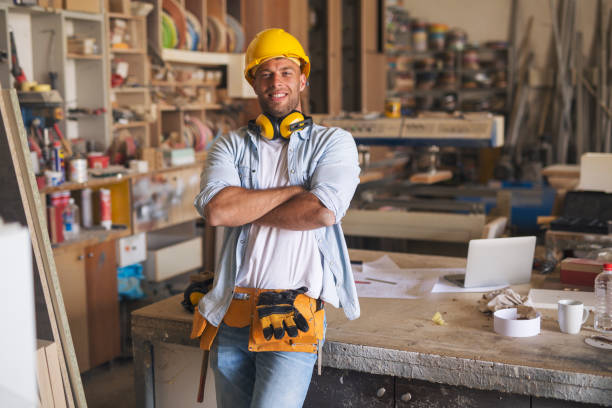 carpenter holding his hands crossed in a joinery - manual worker portrait helmet technology imagens e fotografias de stock