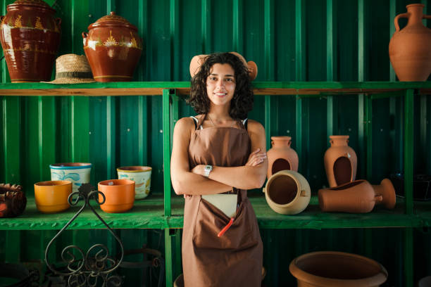 istock Young shop assistant in her ceramic shop surrounded by her products 1257545264
