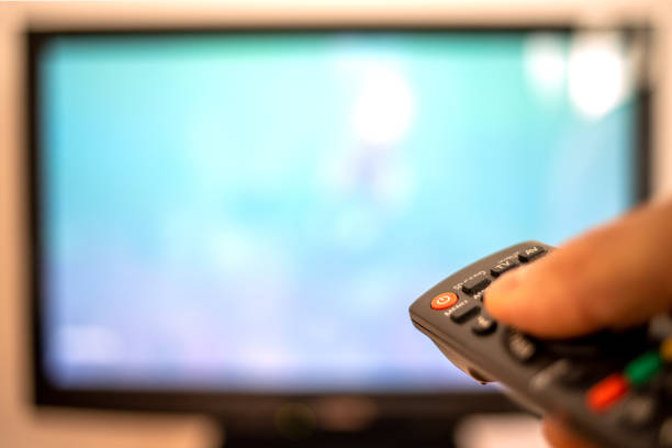 istock Hand with remote control in front of the tv 1257545468