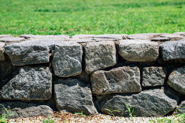 istock Stone wall with green grass filed 1257546219