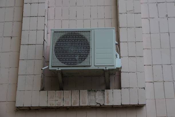 istock one large gray air conditioner hanging on a brown building wall 1257546363