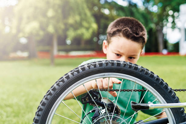Little boy repairing his bicycle