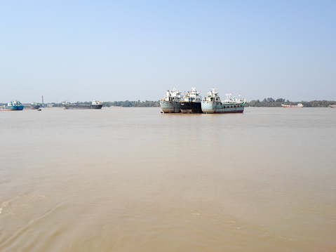 Container Ship in ganga river. Marine Cargo Ships at Calcutta Port and Haldia Port for commercial intermodal freight transport from Kolkata to Bangladesh. Hooghly river West Bengal, India South Asia Pacific December 2020