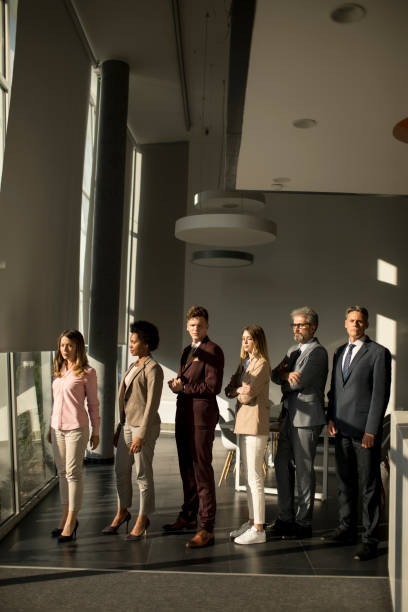 istock Multiethnic corporate staff standing in row and looking in the camera 1257550298