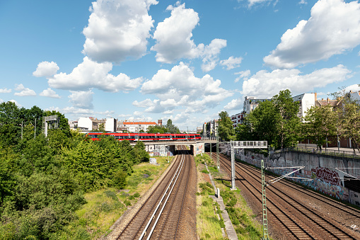 red train on bridge passing railway track in Berlin Prenzlauer Berg in summer