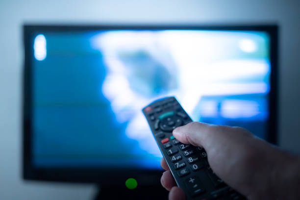istock Hand with remote control in front of the tv 1257552006