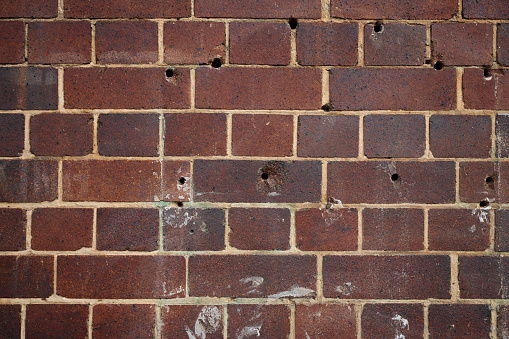 Repeating pattern of bricks in a wall with holes