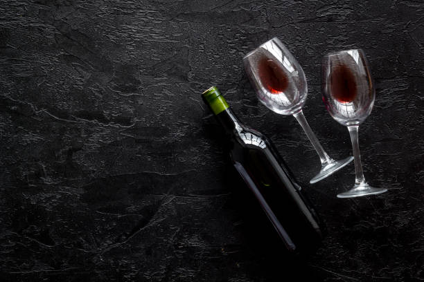 istock Wine bottle and glasses on black background from above copy space 1257558502