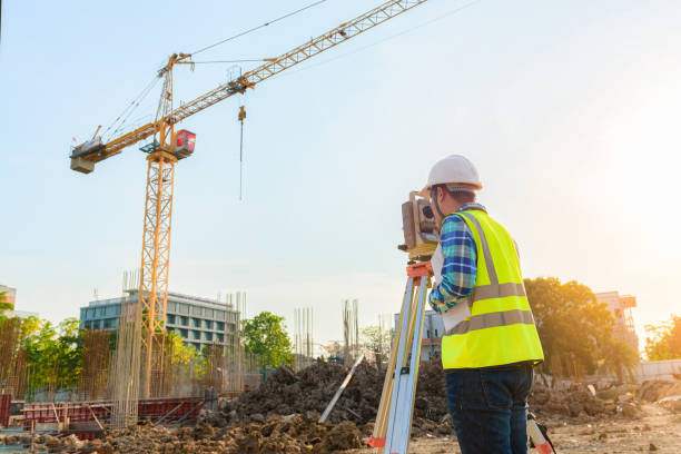 surveying engineers are working together using theodolite on the construction site. - levelling instrument imagens e fotografias de stock