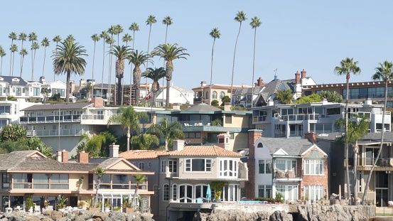 Luxury property, beachfront real estate on pacific ocean coast, Newport beach harbor, California, USA. Weekend premium seafront rental homes near Los Angeles. Vacation rich suburban waterfront houses.