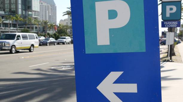Parking lot sign as symbol of traffic difficulties and transportation issues in busy urban areas of USA. Public paid parking zone in downtown of San Diego, California. Limited space for cars in city. señal de estacionamiento como símbolo de las dificultades de tráfico y problemas de transporte en las zonas urbanas concurridas de ee.uu. zona de estacionamiento público de pago en el centro de san diego, california. espacio limitado para coches en la