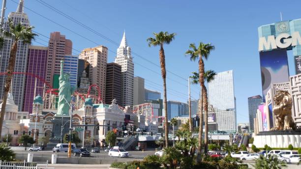 the strip boulevard with luxury casino in gambling sin city. car traffic on road to fremont street, tourist money playing resort. new york hotel and liberty statue - downtown las vegas fremont street experience nevada las vegas metropolitan area imagens e fotografias de stock