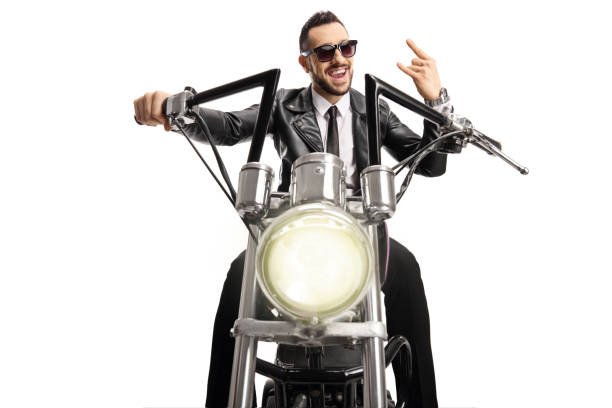 istock Biker with sunglasses riding a custom chopper and gesturing rock and roll sign 1257561991