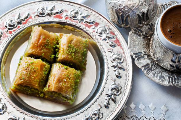 Baklava with walnut and pistachio. Turkish dessert with coffee and traditional silver serving set. Festival of sacrifices. Ramadan holiday stock photo